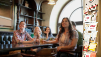 Fans beim Fußballschauen in der Keipe. Aufsteller mit Sky Sport Edgar Cards