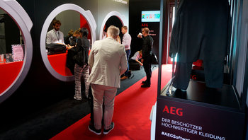 Besucher an der Garderobe in Form von riesigen Waschmaschinentrommeln