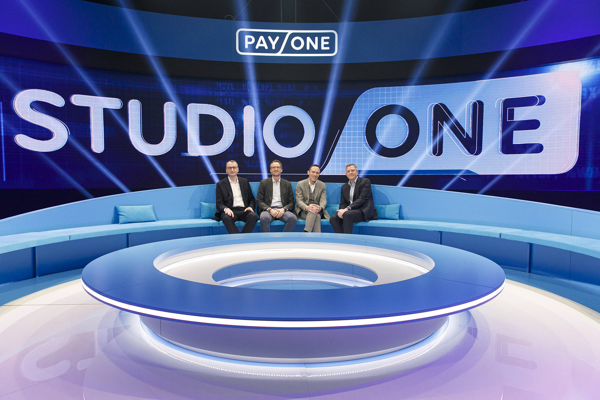 Payone Geschäftsführung sitzt zusammen vor Leinwand